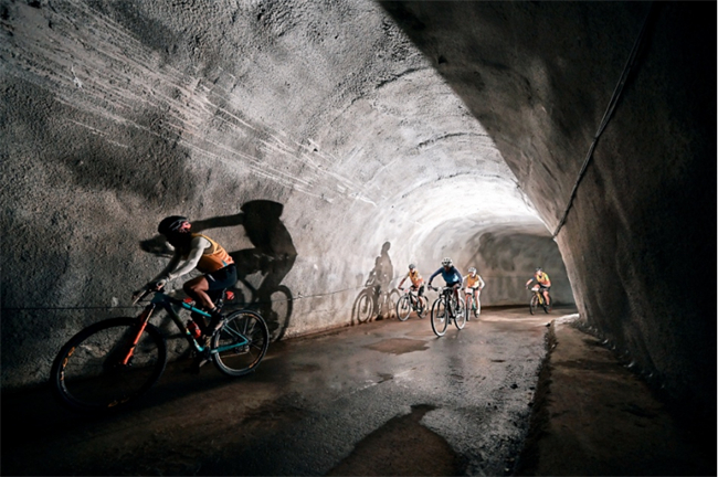 山地车项目比赛中，参赛选手穿越隧道。赛事组委会供图